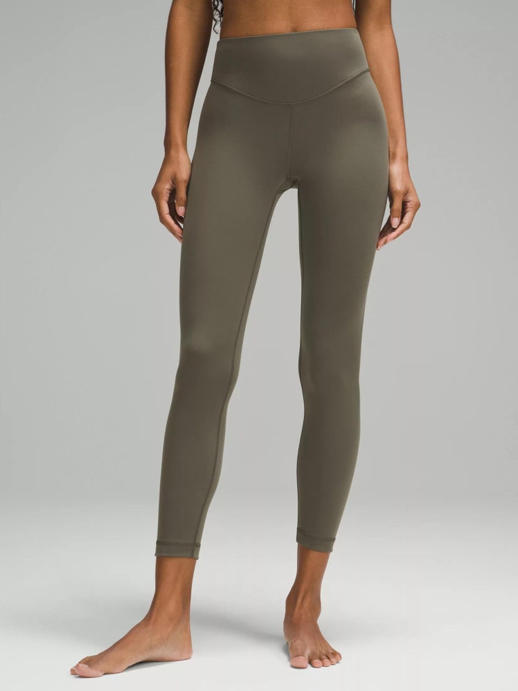 A model wearing an olivecolored pair of leggings.